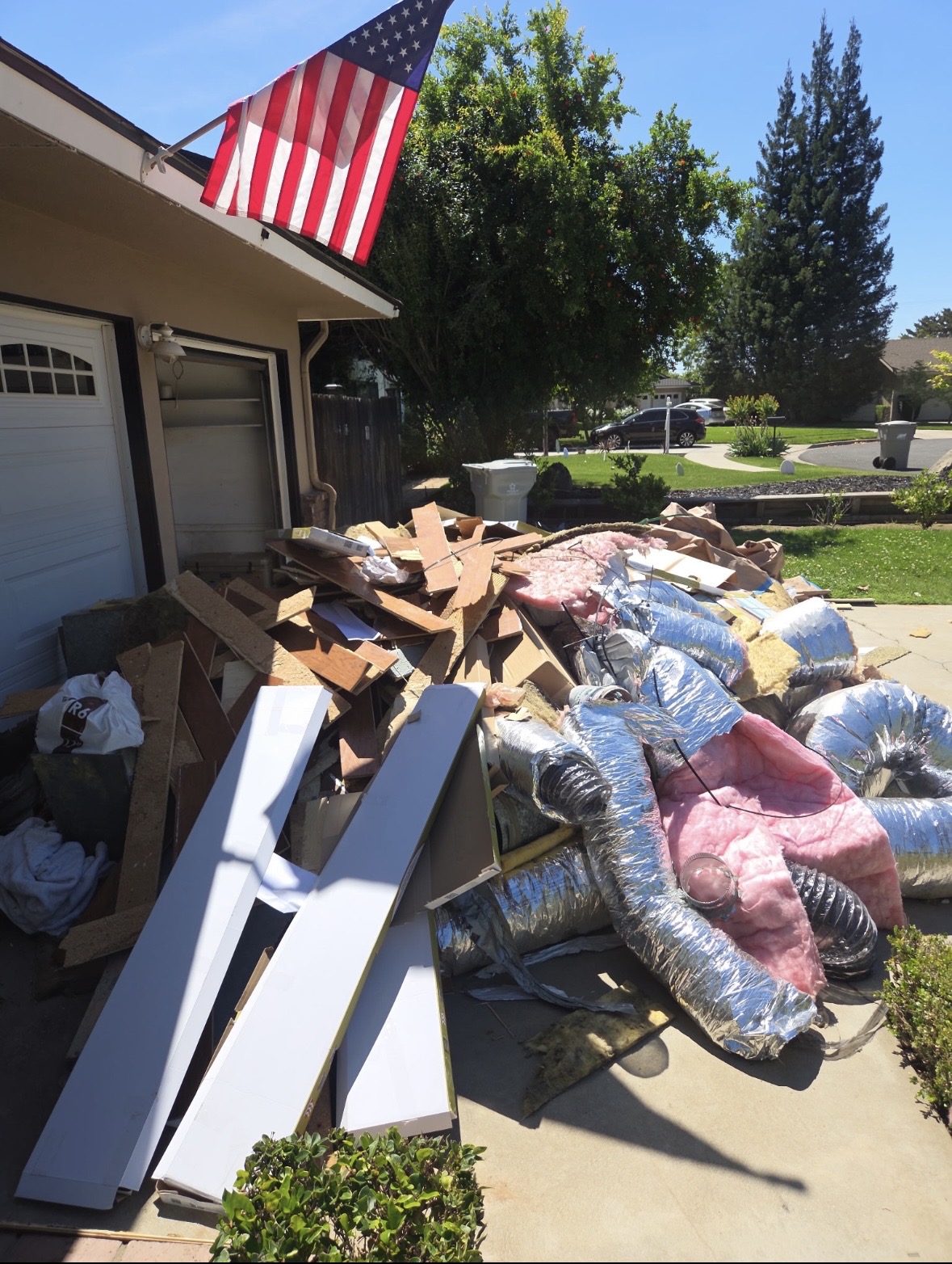 Driveway piled with junk and debris before hauling