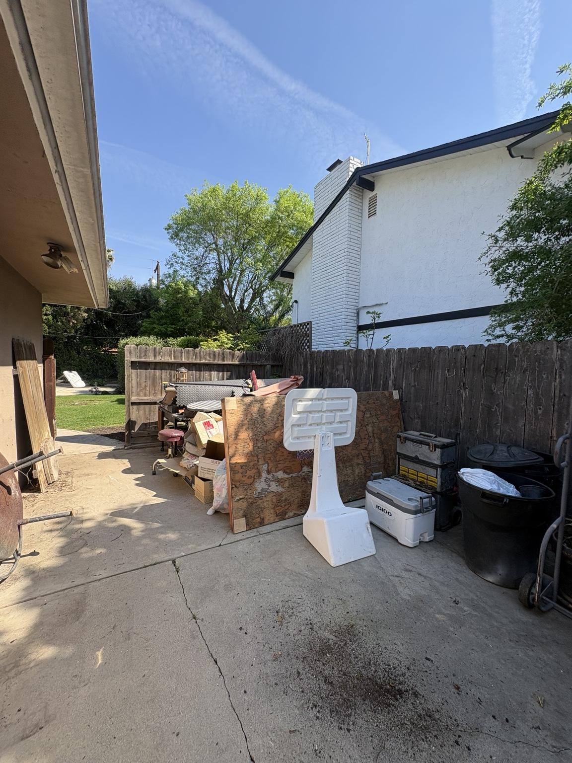 Backyard cluttered with junk and debris before cleanout