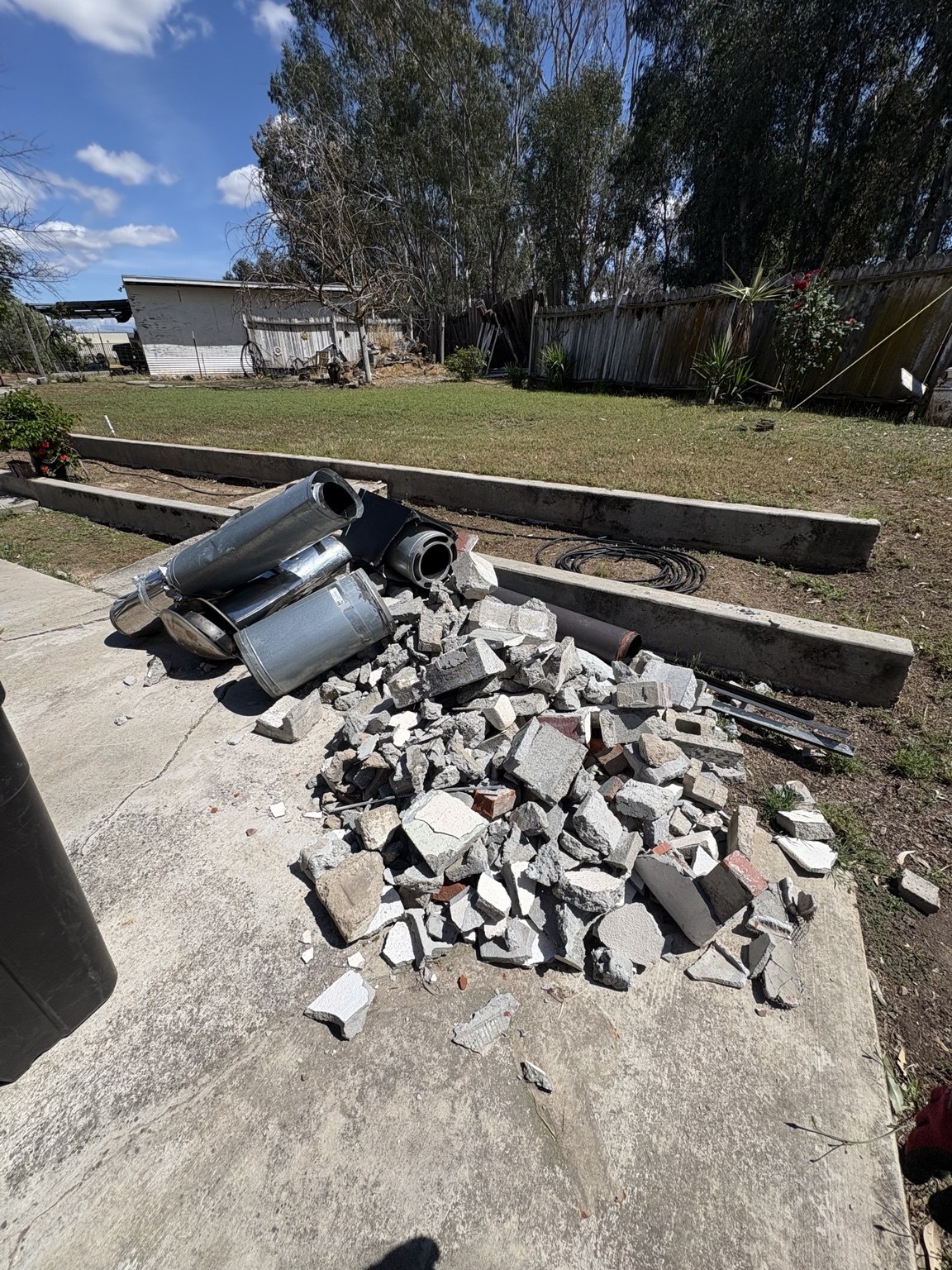Yard with rubble and concrete debris before cleanup